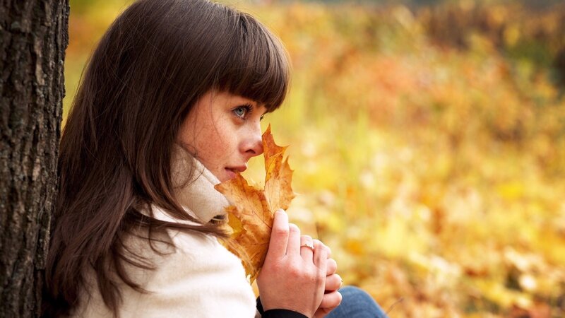 Woman Holding Autumn Leaf — Yellow, Contemplative, Photograph