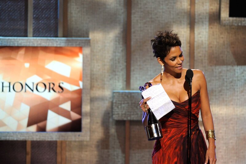 woman holding award on stage