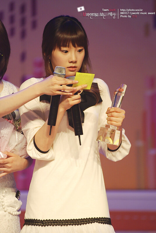 woman holding award on stage