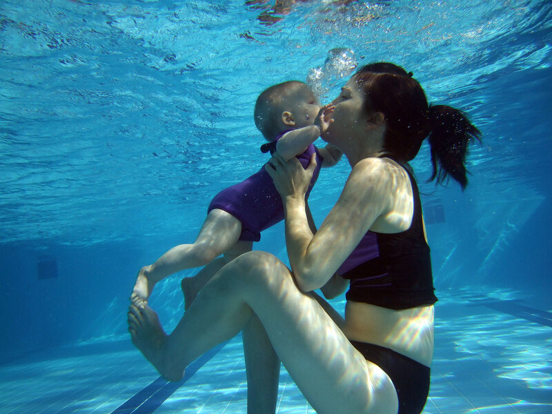 Woman Holding Baby Underwater
