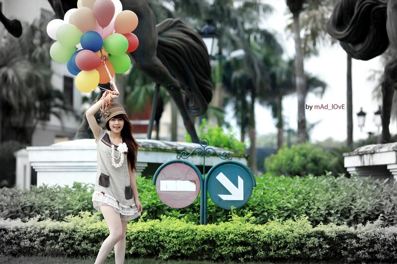 Woman holding balloons in park