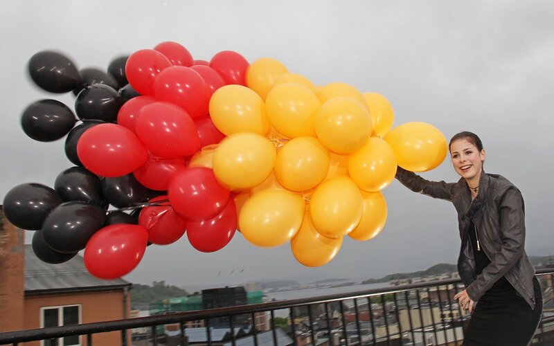 Woman holding balloons on balcony