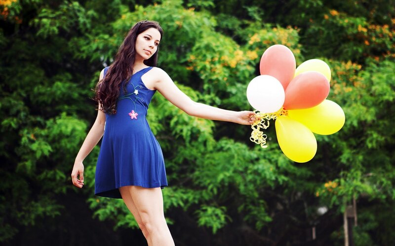 Woman holding balloons outdoors