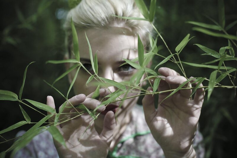 woman holding bamboo leaves