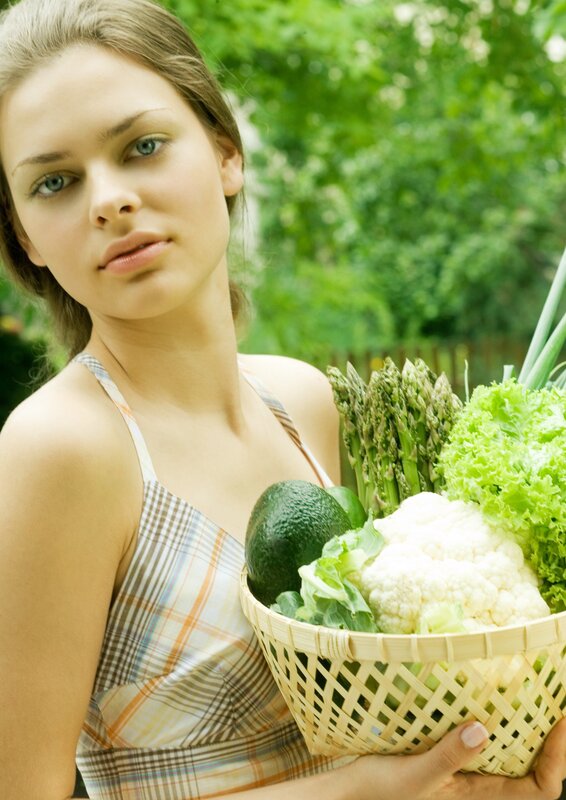 woman holding basket of vegetables