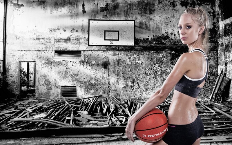 woman holding basketball in abandoned gym