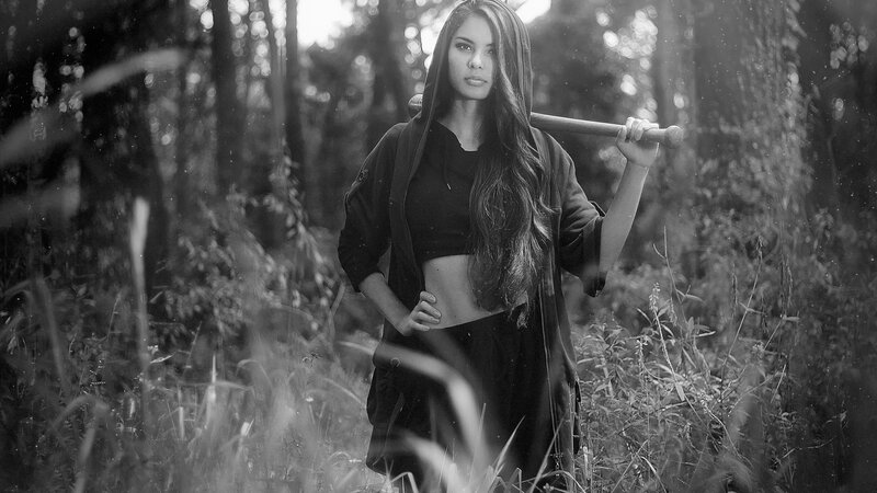 Woman Holding Bat in Forest