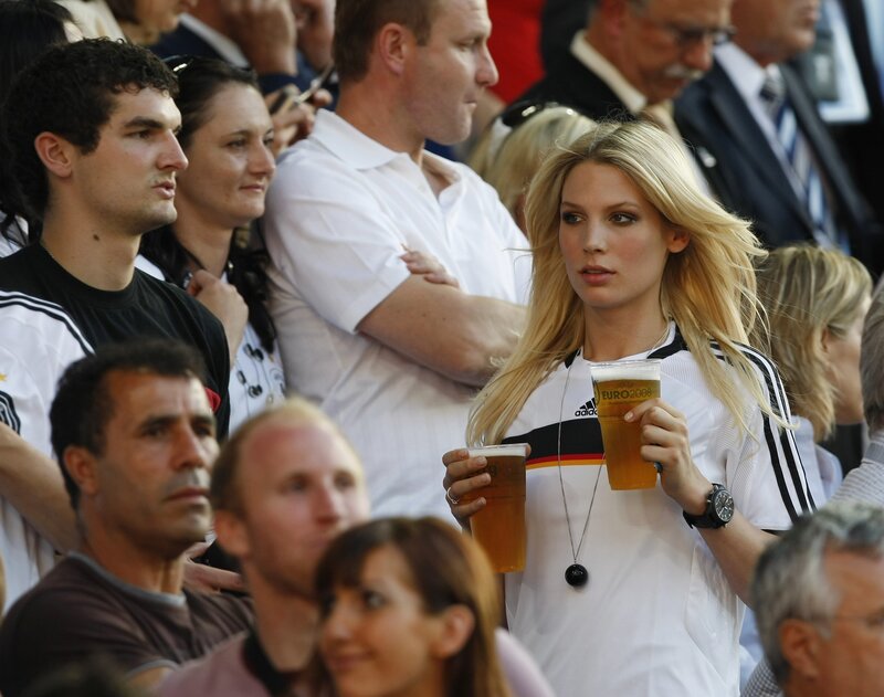 Woman holding beer at football match