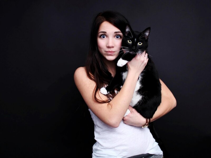 woman holding black and white cat