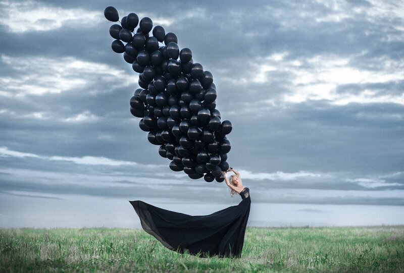 Woman Holding Black Balloons