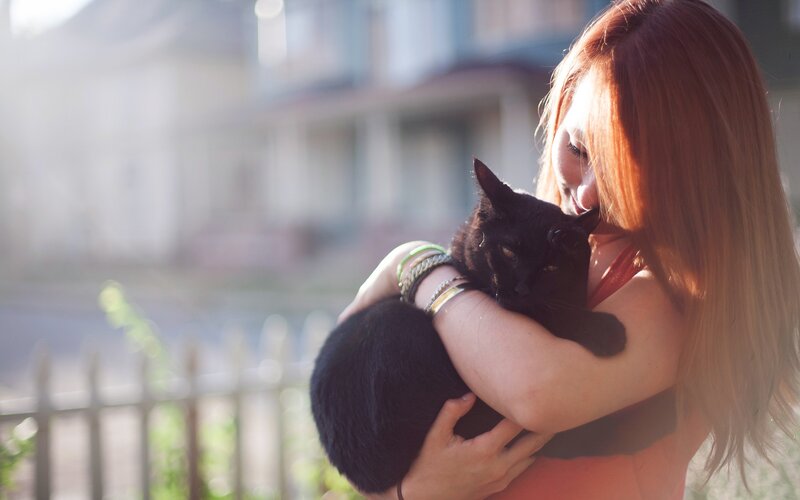 woman holding black cat