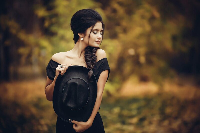 Woman Holding Black Hat — Serene