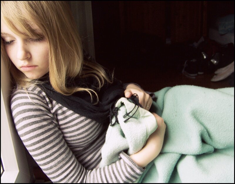 woman holding blanket by window