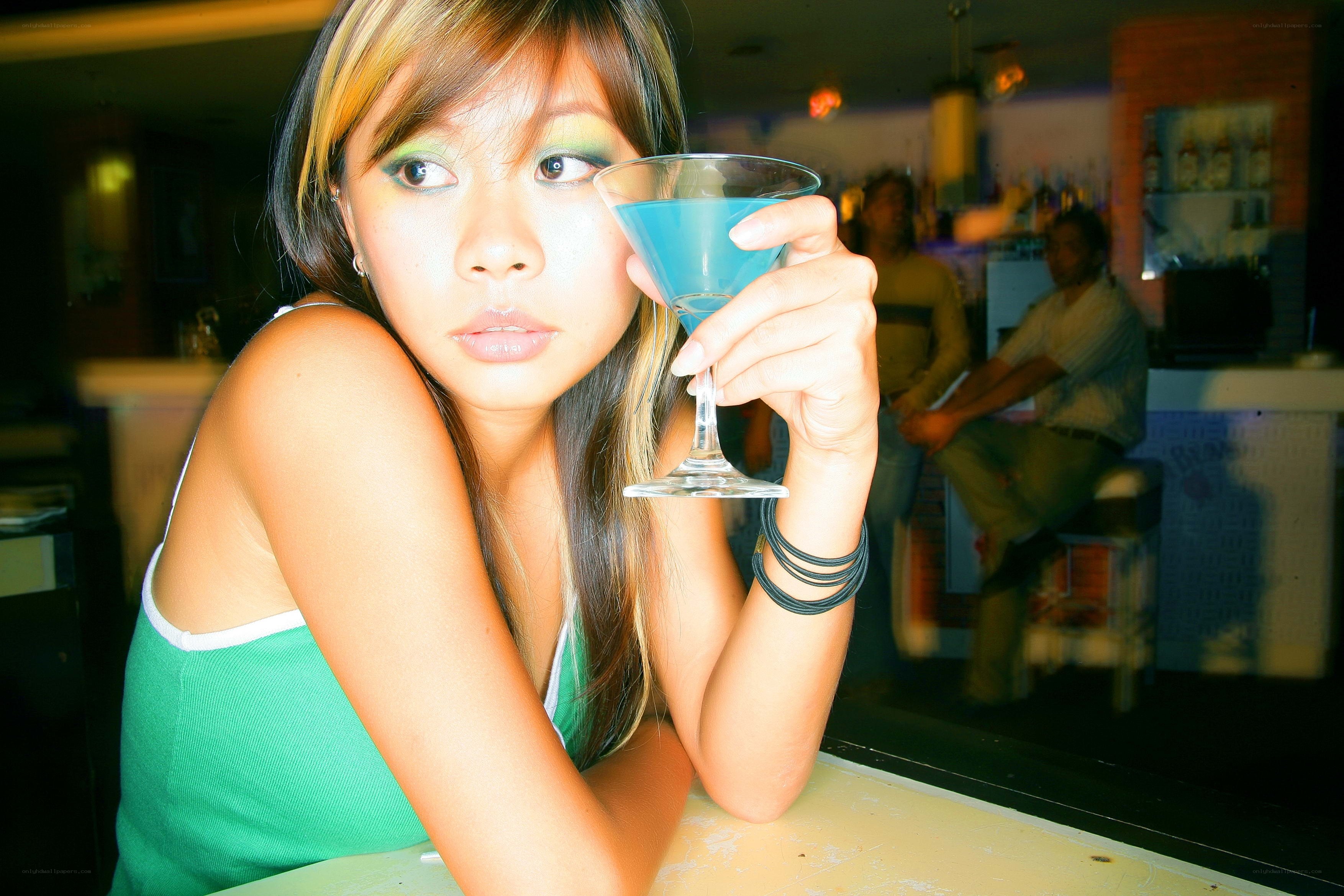woman holding blue cocktail