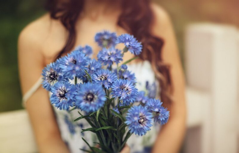 Woman Holding Blue Flowers — Serene