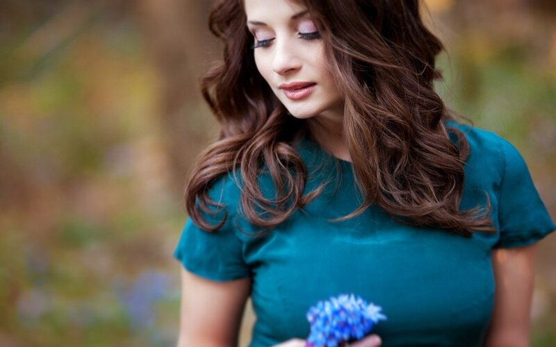 Woman Holding Blue Flowers — Teal