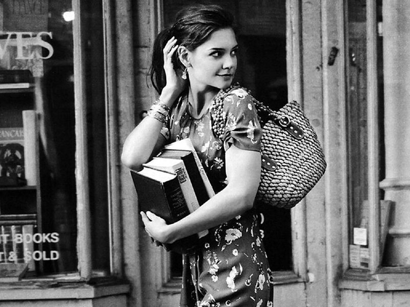 woman holding books outside bookstore