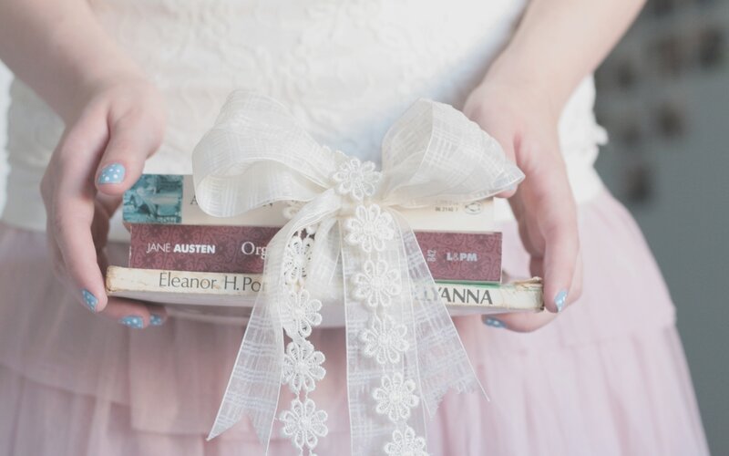 woman holding books with ribbon