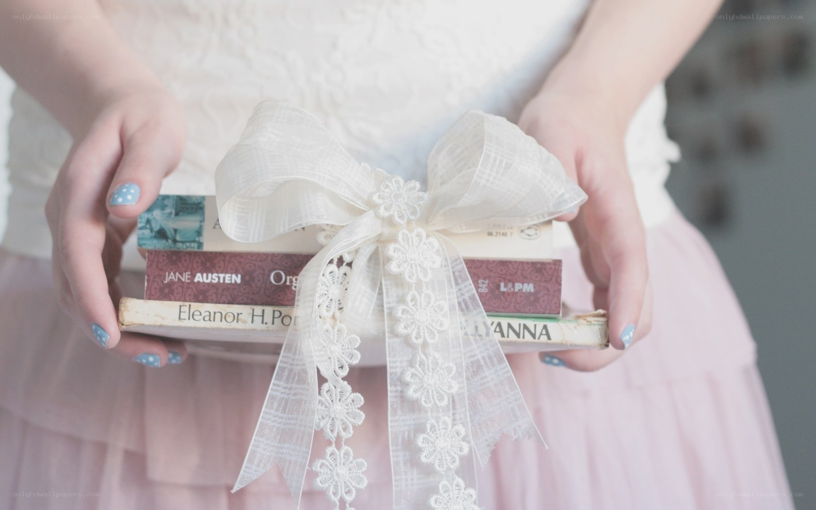woman holding books with ribbon
