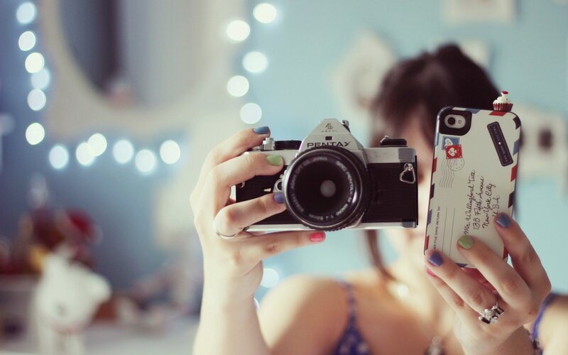 woman holding camera and phone