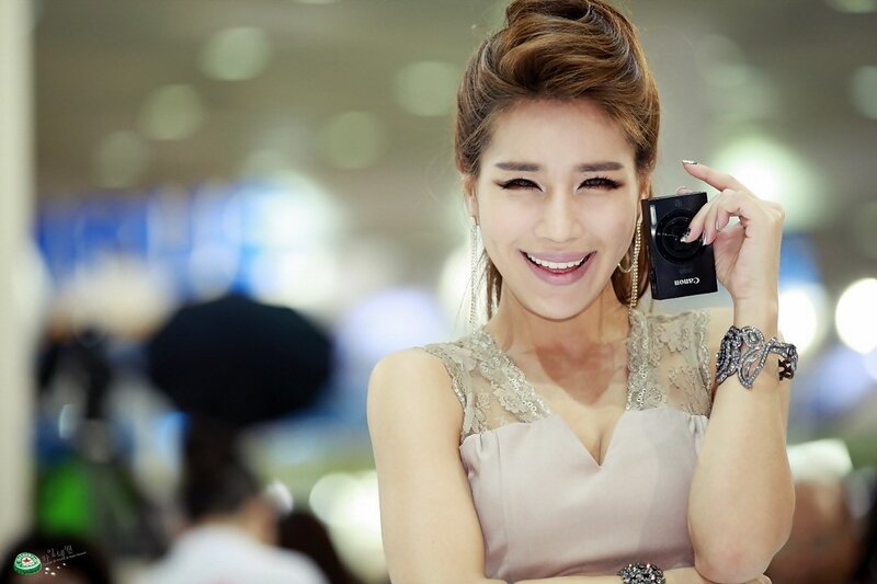 Woman Holding Camera — Beige, Smiling