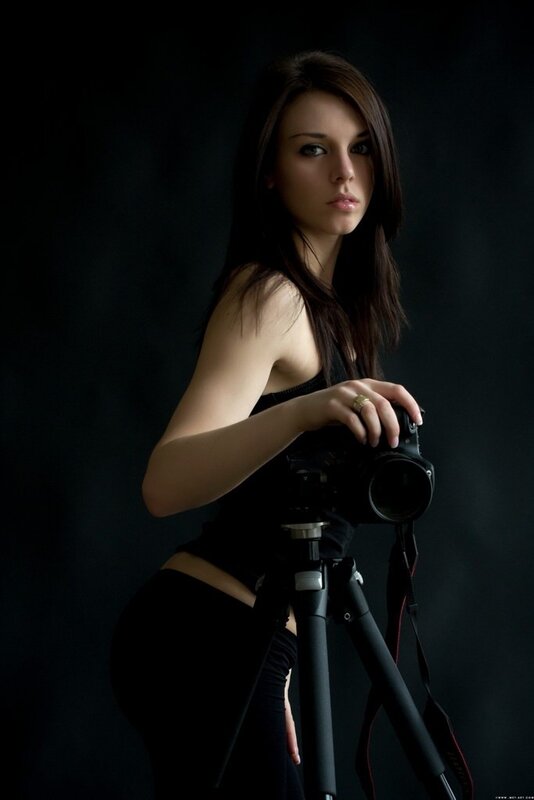 Woman Holding Camera — Black, Dramatic, Photograph, Tripod, Black Background, Dark Gray, Portrait