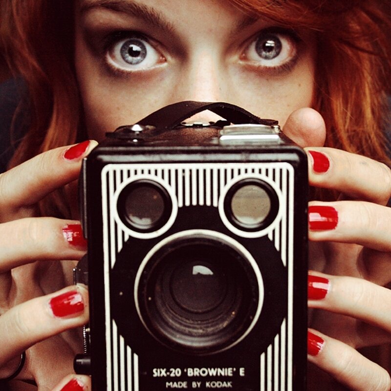 Woman Holding Camera — Black, Playful
