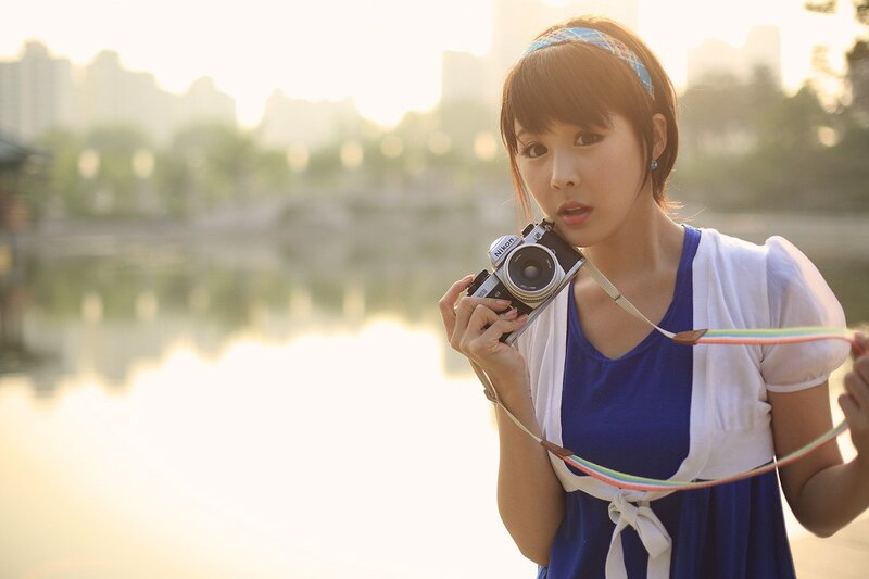 Woman Holding Camera — Blue, Serene, Sunset