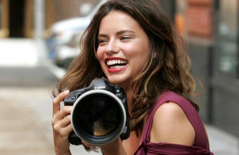 Woman Holding Camera — Brown, Happy