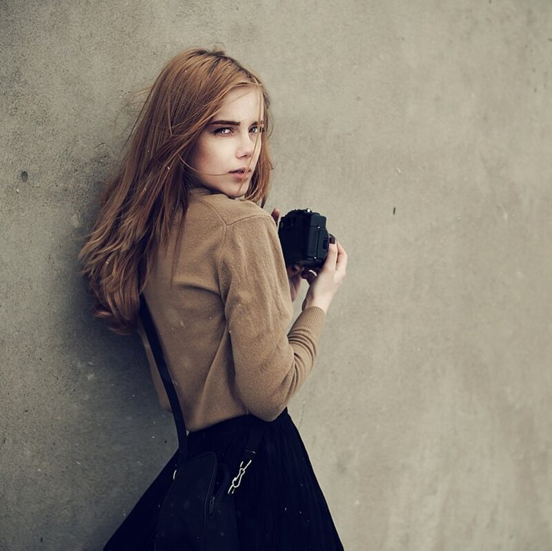 Woman Holding Camera — Brown, Serious