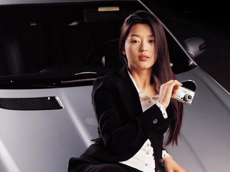 woman holding camera by car