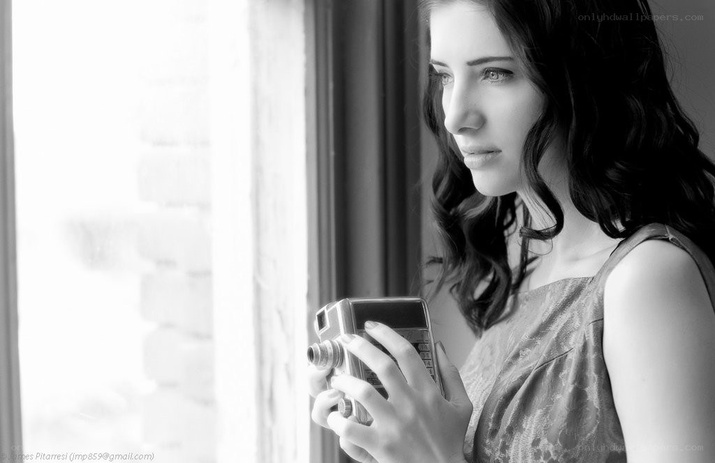 woman holding camera by window