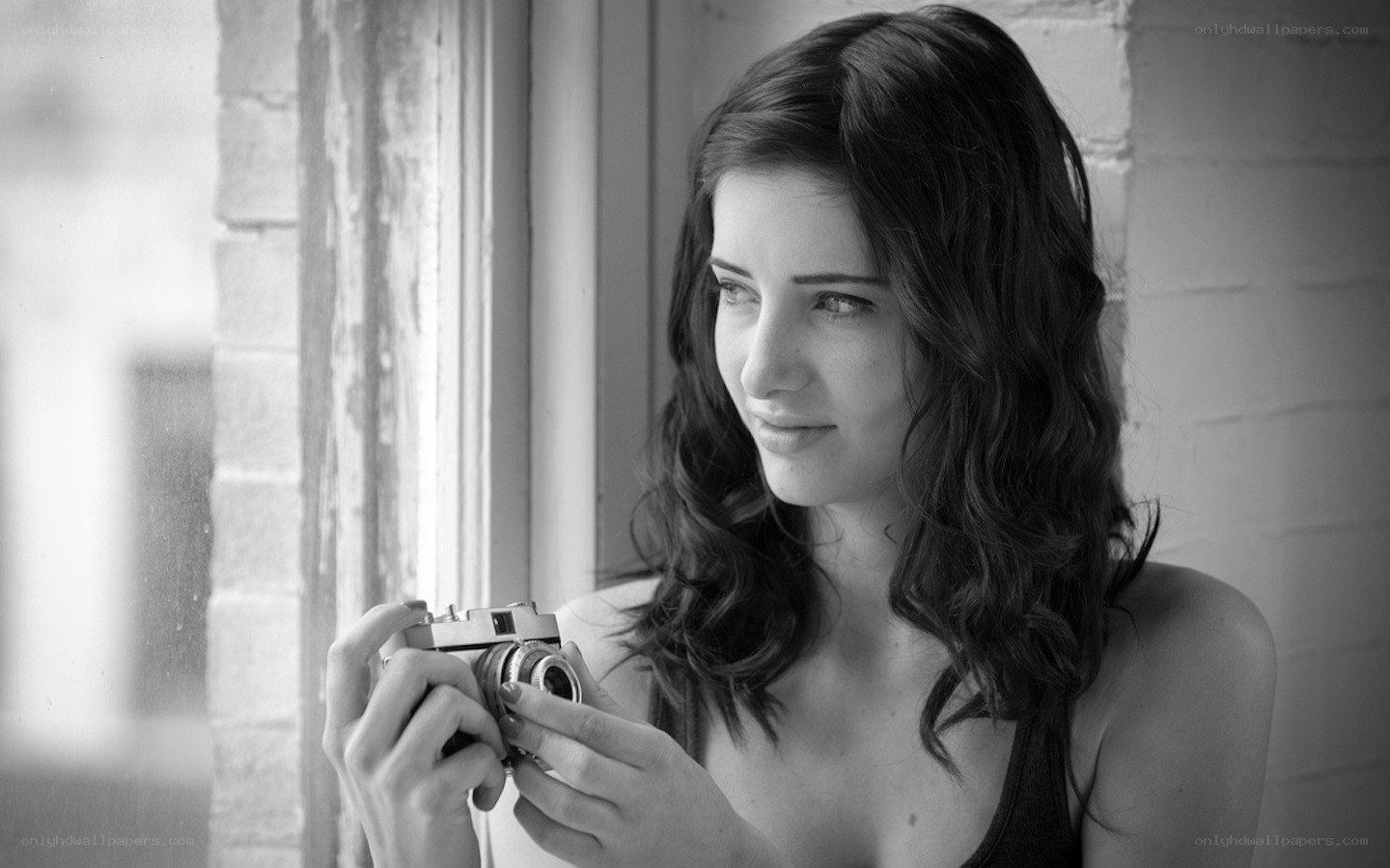 woman holding camera by window