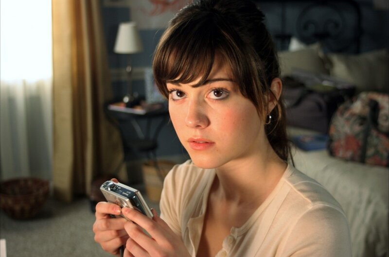 woman holding camera in bedroom