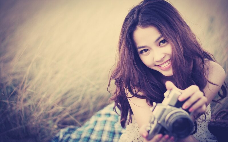 woman holding camera in field