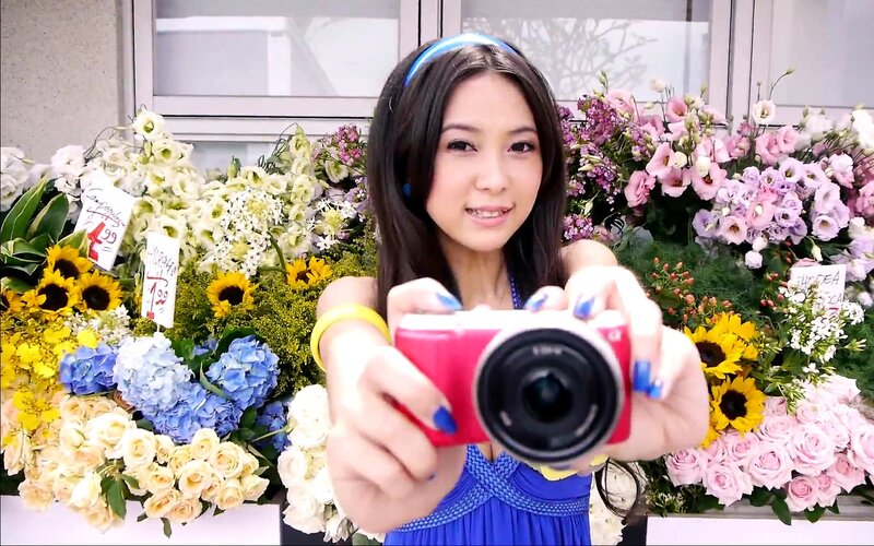 Woman holding camera in flower shop