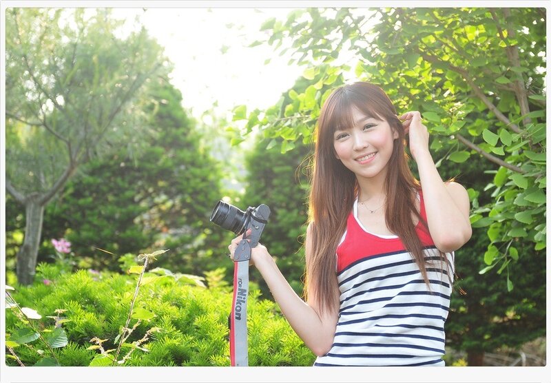 Woman holding camera in garden