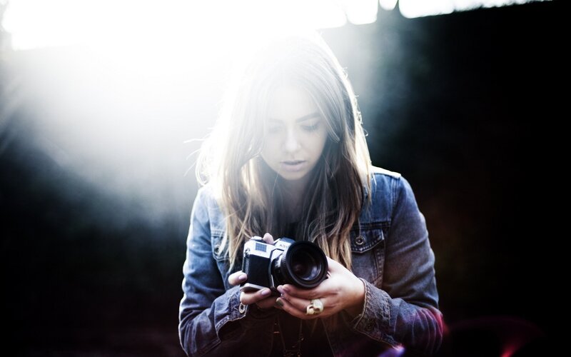 woman holding camera in sunlight