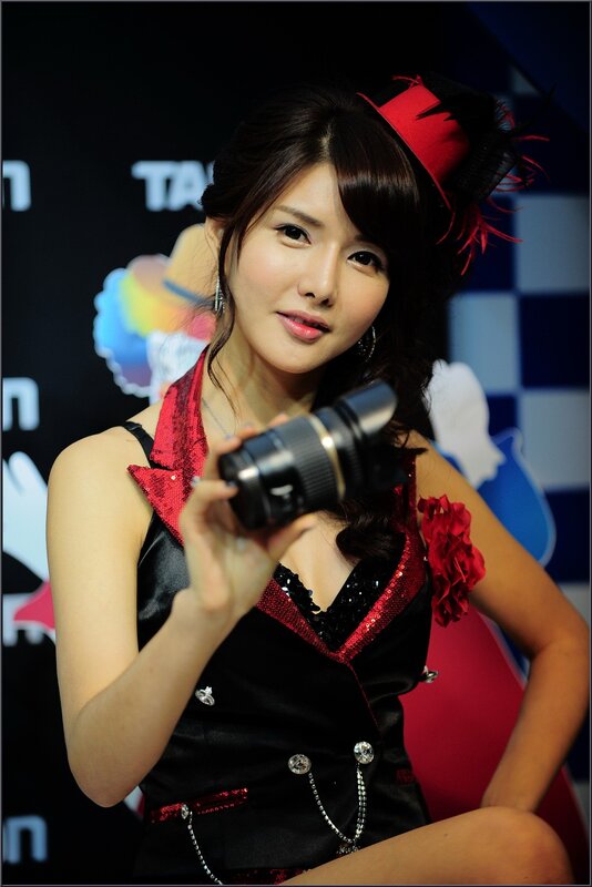 Woman Holding Camera Lens — Black, Neutral, Photograph, Camera Lens, Red Hat