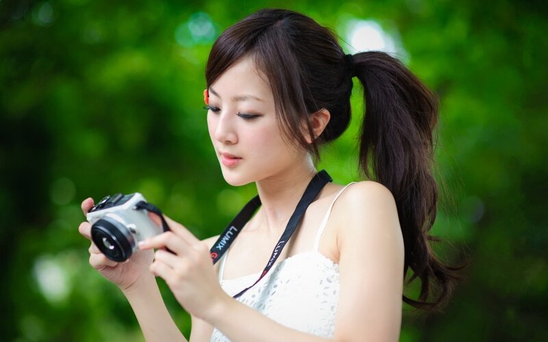 woman holding camera outdoors