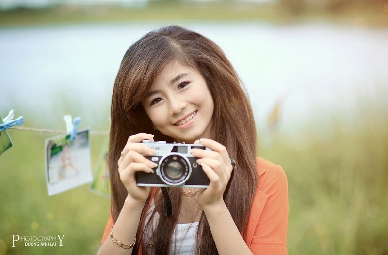 Woman holding camera outdoors