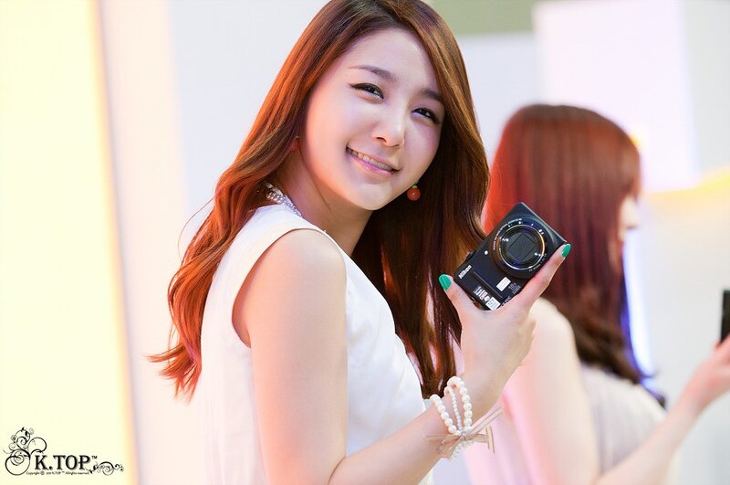 Woman Holding Camera — White, Friendly
