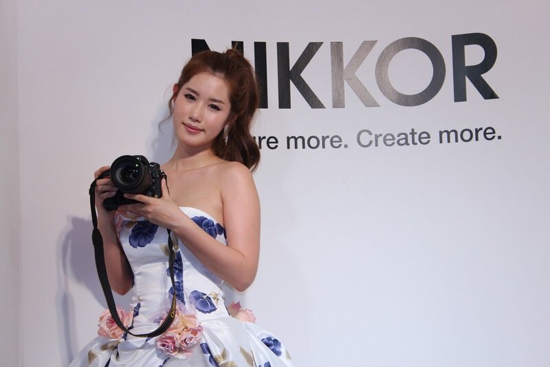 Woman Holding Camera — White, Neutral, Photograph, Dress, Wall