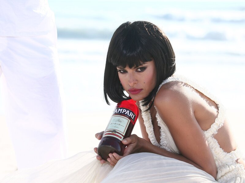 Woman holding Campari bottle on beach