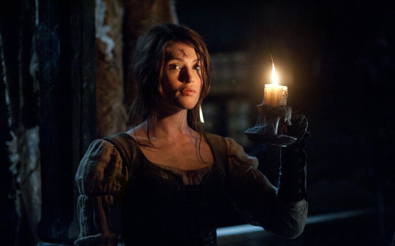 woman holding candle in dark room