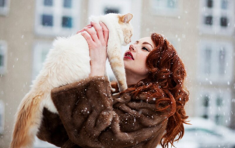 Woman Holding Cat in Snow — Brown