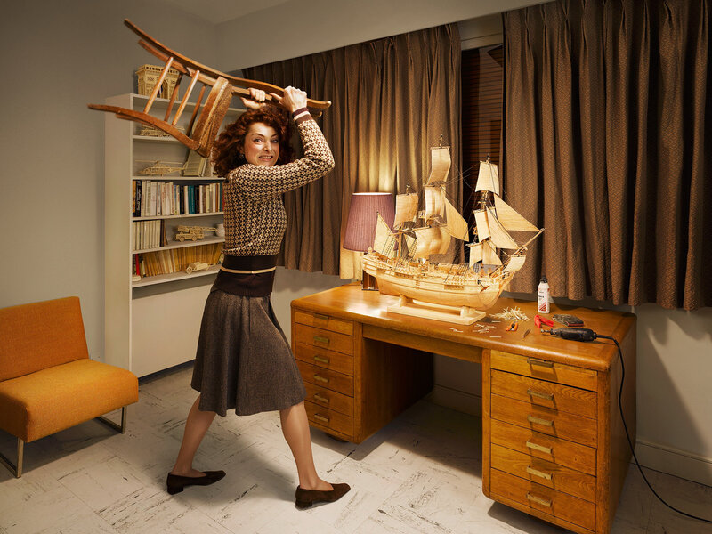 Woman holding chair over head