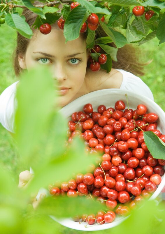 woman holding cherries in garden