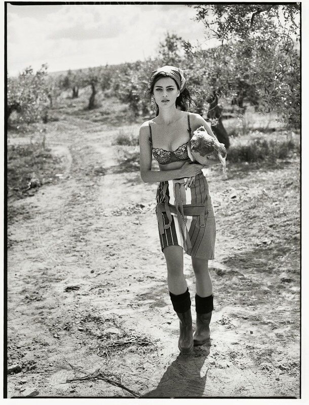 Woman holding chicken in olive grove