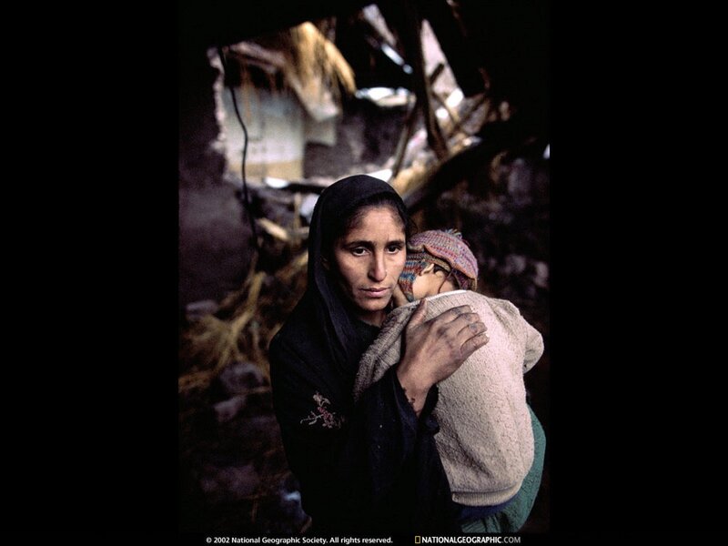 Woman holding child in rubble